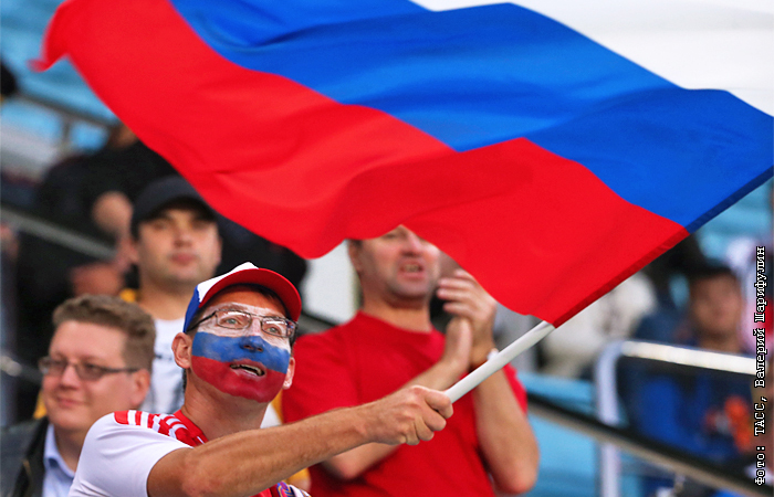 футбольные болельщики с флагами в напряжении