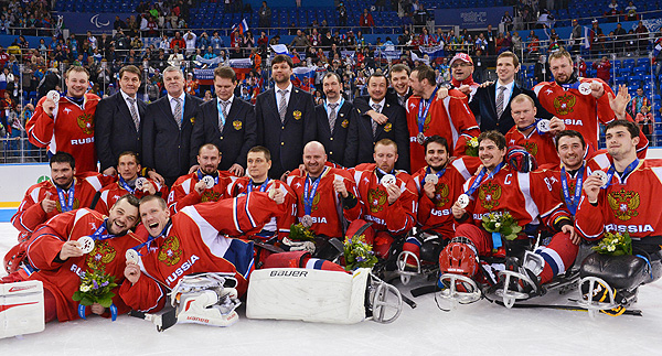 Игроки и тренеры сборной России, завоевавшие серебряные медали на соревнованиях по следж-хоккею на XI зимних Паралимпийских играх в Сочи, во время медальной церемонии.