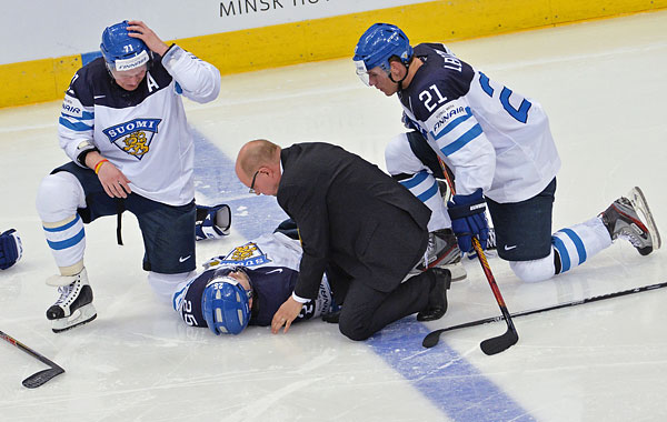Врач оказывает первую помощь игроку сборной Финляндии Пекке Йормакку (в центре).