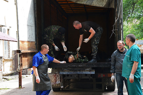 У морга Калининской больницы Донецка, где идет опознание погибших в результате обстрела украинской армией двух "Камазов", которые вывозили раненых с места боя около аэропорта.