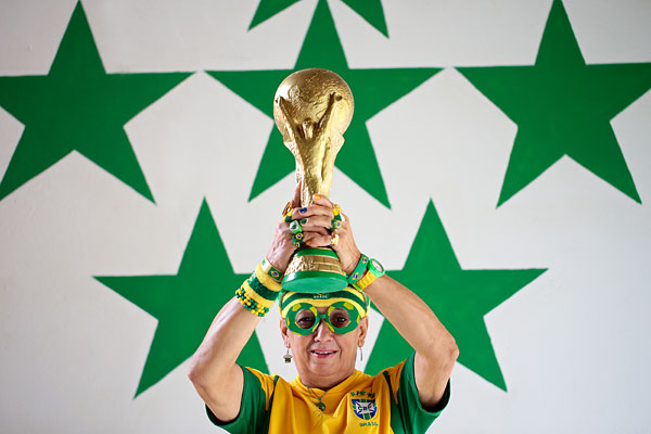 Бразильская фанатка держит в руках точную копию кубка чемпионата мира по футболу.