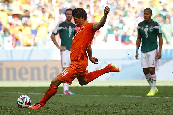 Нападающий сборной Голландии Клас-Ян Хунтелар исполняет пенальти на четвертой добавленной минуте матча 1/8 финала против Мексики. Команда Нидерландов победила со счетом 2:1 и вышла в четвертьфинал.