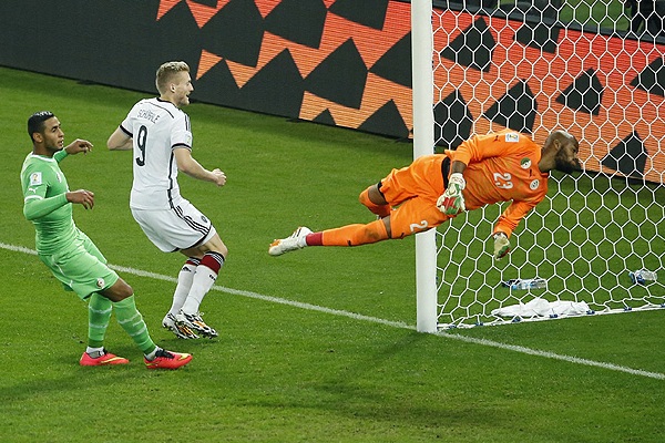 Нападающий сборной Германии Андре Шюррле (№9) забивает гол в ворота команды Алжира в матче 1/8 финала чемпионата мира по футболу.