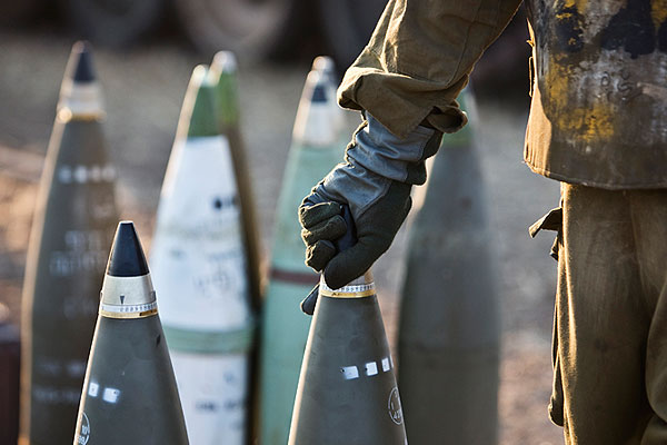 Израильский военный заряжает снаряд.