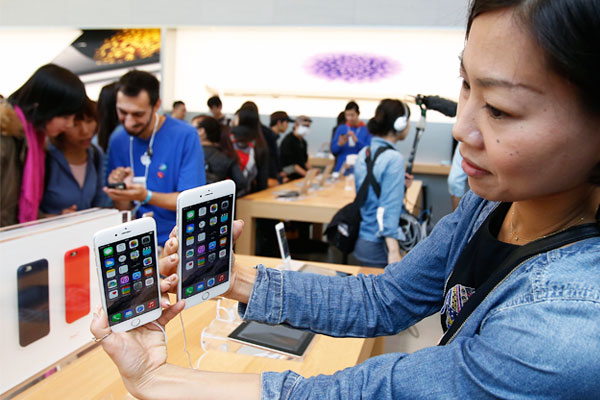 Покупательница демонстрирует новинки компании Apple в Токио.