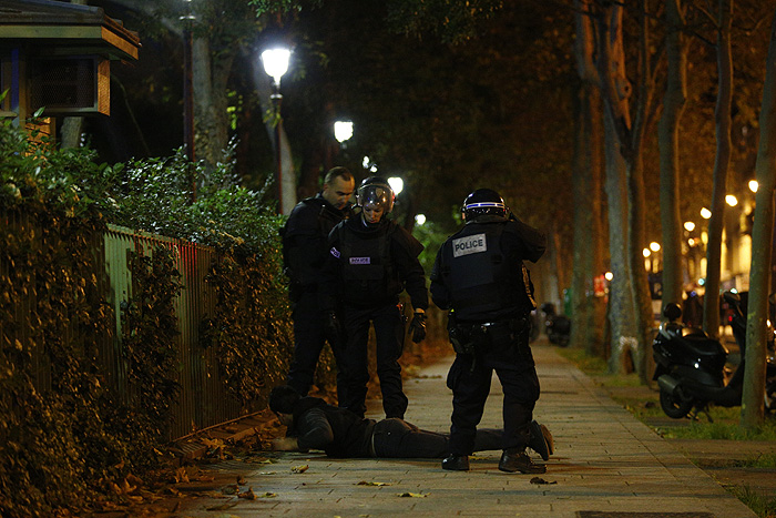 Парижские полицейские проверяют мужчину возле клуба "Батаклан", где в пятницу вечером произошел захват заложников.