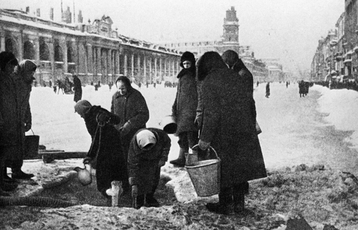 Ленинградцы запасаются водой из разрушенной водопроводной трубы на Невском проспекте. 1941 год.