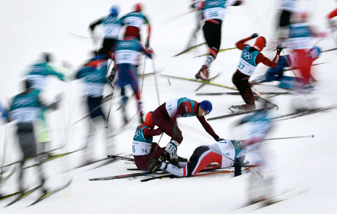 Падение будущего победителя скиатлона, норвежского лыжника Симена Крюгера (№7) и россиян Андрея Ларькова (№11) и Дениса Спицова (№16)