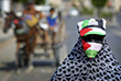 1 сентября. Женщина закрывает лицо палестинским флагом в качестве превентивной меры против коронавирусной болезни в городе Газа.