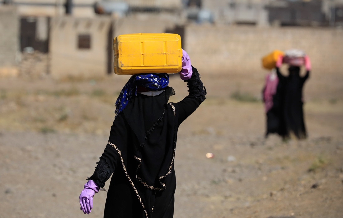 Женщина несет воду в Сане, Йемен