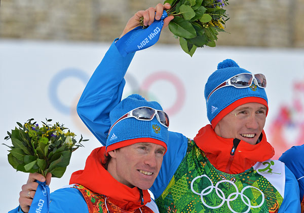 Слева направо: Максим Вылегжанин (Россия), Никита Крюков (Россия), завоевавшие серебряные медали в командном спринте на соревнованиях по лыжным гонкам среди мужчин на XXII зимних Олимпийских играх в Сочи, во время цветочной церемонии.